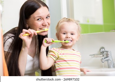 Happy Family Mother And Daughter Kid Girl Brushing Teeth Together