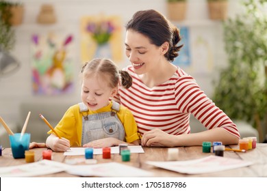Happy family  Mother   daughter painting together  Adult woman helping to child girl                                 