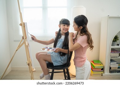 Happy Family Mother And Daughter Painting Brush On Canvas Together At Home.