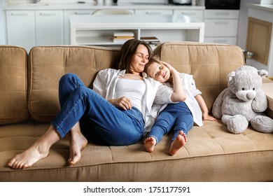 Happy family, mother and daughter are sitting on the sofa at home. Have fun and fun together. Mom hugs daughter. The concept of a happy family. - Shutterstock ID 1751177591