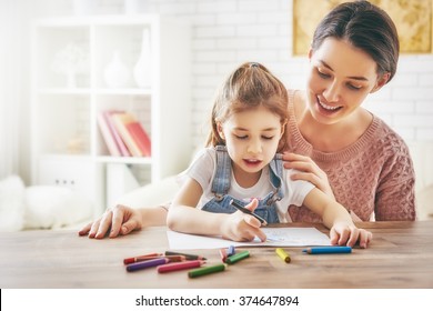 Happy family  Mother   daughter together paint  Adult woman helps the child girl 