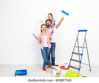 Happy Family Mother Father And Baby Daughter Are Doing Repairs Paint Wall At Home