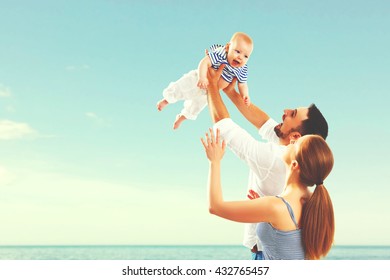 Happy Family Mother, Father And Baby On The Sea In Summer