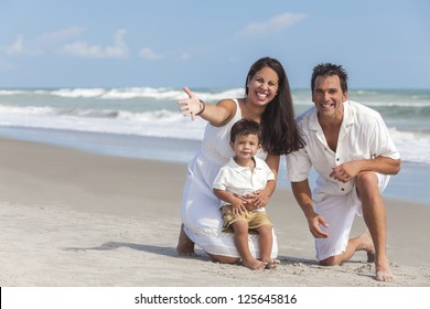 A Happy Family Of Mother, Father And Boy Child Son, Playing And Having Fun In The Sand Of A Sunny Beach.