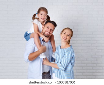 happy family mother father and child daughter near an empty brick wall