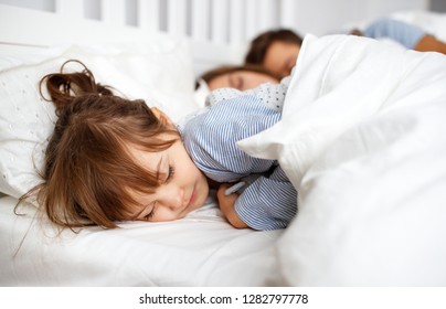 Happy Family Mother, Father And  Father Child Daughter R Sleeping In Bed
