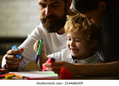 Happy family mother father and child son drawing laughing. Early childhood education, kids creative growth. Parents and their little child painting writing in book with pencil making homework at home.