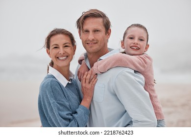 Happy Family, Mother And Father With Child At A Beach Enjoying Winter Holiday Vacation And Bonding Outdoors. Smile, Mom And Girl Hugging Dad, Relaxing And Spending Quality Time At An Ocean In Sydney