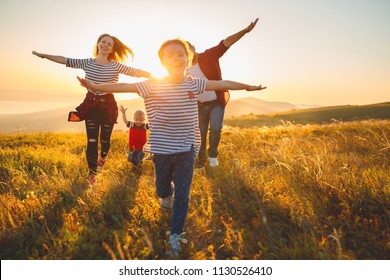 Happy Family: Mother, Father, Children Son And  Daughter On Nature  On Sunset
