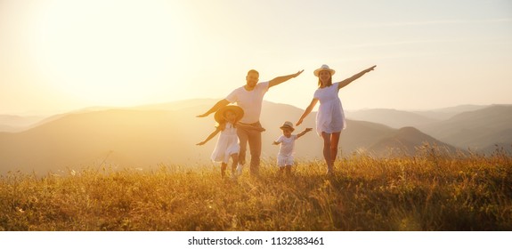 Fröhliche Familie: Mutter, Vater, Kinder Sohn und Tochter auf der Natur bei Sonnenuntergang