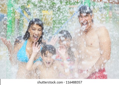 A Happy Family Of Mother, Father And Children, Son And Daughter, Having Fun On Vacation At A Water Park