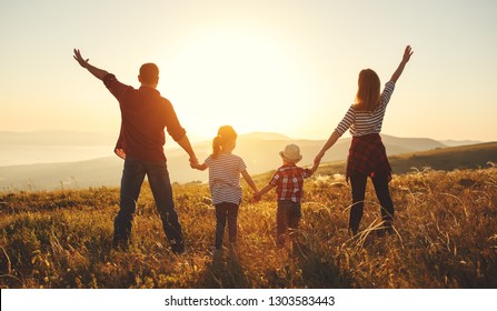 Счастливая семья: мать, отец, дети сын и дочь на природе на закате