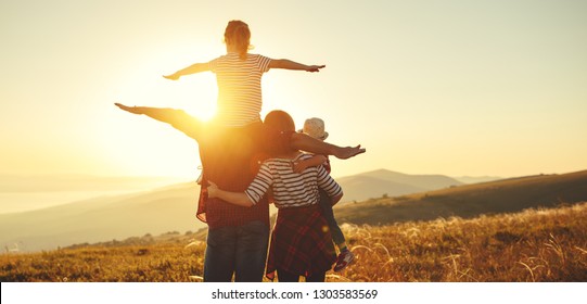 Happy Family: Mother, Father, Children Son And  Daughter On Nature  On Sunset
