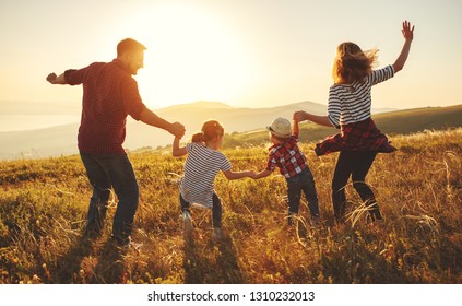 Happy family: mother, father, children son and  daughter on nature  on sunset