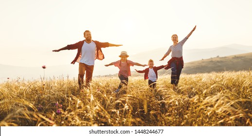 Счастливая семья: мать, отец, дети сын и дочь на природе на закате