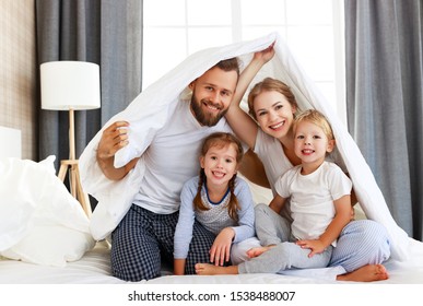 happy family mother, father and children laughing, playing and smiling in bed in bedroom at home - Shutterstock ID 1538488007