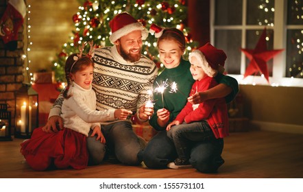 happy family mother, father and children celebrate Christmas and new year, light sparklers
