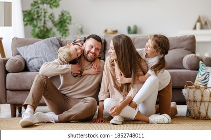happy family mother father and children at home on floor next to the sofa