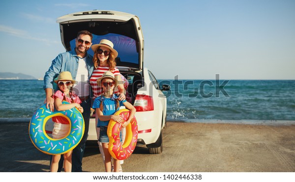 happy   family mother father and\
children in summer auto journey travel by car on\
beach\
