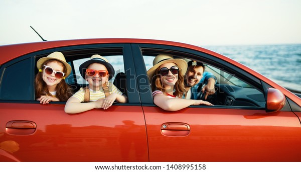 happy family mother father and children in\
summer auto journey travel by car on\
beach\
