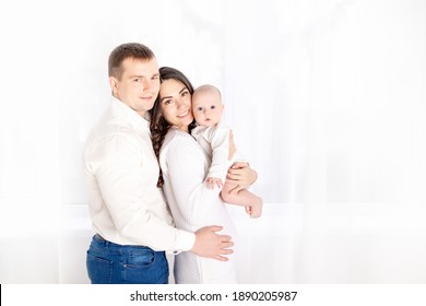 glückliche Familie Mutter und Vater halten ein Neugeborenes zu Hause, das Konzept der glücklich liebenden Familie, Lebensstil