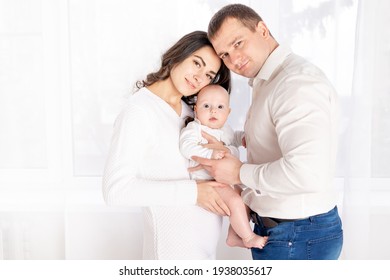 Happy Family Mother And Father Hold A Newborn Baby At Home, The Concept Of Happy Loving Family, Lifestyle