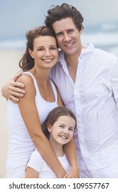 A happy family of mother, father and one child, a daughter, embracing and having fun on a sunny tropical beach