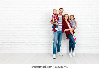 Happy family mother, father, son, daughter on a white blank brick wall background