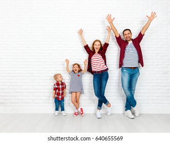 Happy Family Mother, Father, Son, Daughter On A White Blank Brick Wall Background
