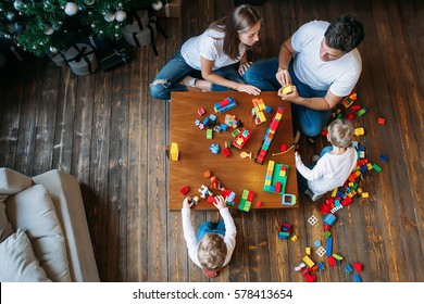 happy family mother father twins boys playing with constructor at home on table - Powered by Shutterstock