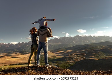 Happy family of mother father and young son walks in mountains. Active weekend travel concept