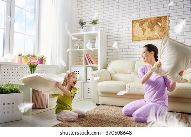 Happy Family! The Mother And Her Child Girl Are Fighting Pillows. Happy Family Games.