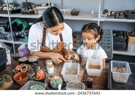 Happy family mother and her daughter concept, asian young mom and baby girl spending time together with planting, parent and her child doing hobby, the quality time for children activities at home.