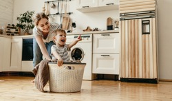 Happy Family Mother Housewife And Child Son In Laundry With Washing Machine 
