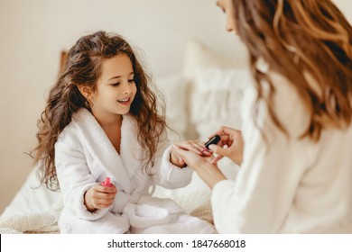 Happy Family Mother And Little Daughter In Bathrobe  Makes Manicure, Laugh On  Spa Day In Bed At Home  
