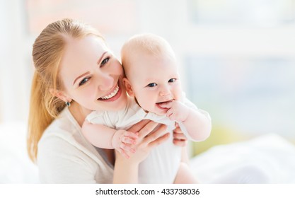 happy family mother playing and hug with newborn baby  in bed - Powered by Shutterstock