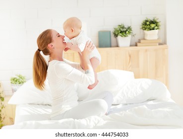 happy family mother playing and hug with newborn baby  in bed - Powered by Shutterstock