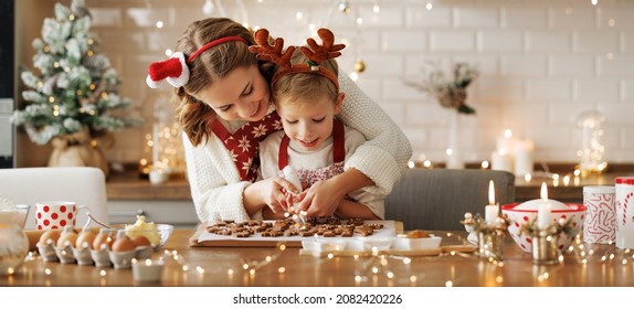 Happy family mother and son in aprons making Christmas cookies together while cooking in kitchen at home, smiling little boy helping mom to decorate xmas gingerbreads during winter holidays - Powered by Shutterstock