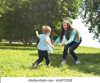 Happy Family! Mother With Son Child Playing Having Fun Together On The Grass In Sunny Summer Day, Life Moment