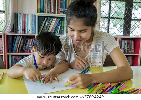 Happy family. Mother and son together paint. Adult woman helps the child boy.Close up.