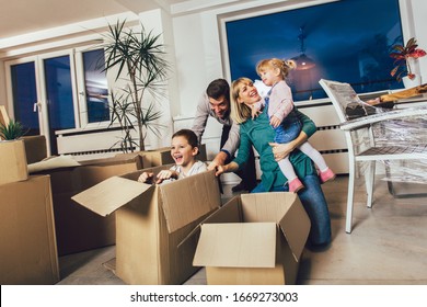 Happy Family Moving Home With Boxes Around