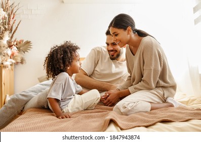 happy family multi ethnic mother, father and son  laughing, playing,and tickles in bed in bedroom at home