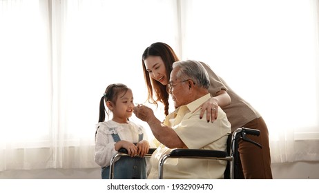 Happy Family Multi-generation Mother and daughter taking care of the senior grandfather in the house, sitting on the wheelchair happiness, Elderly retirement concept. - Powered by Shutterstock