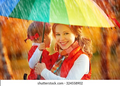 Happy Family Mum And Child Daughter With Rainbow Colored Umbrella Under Rain On Nature