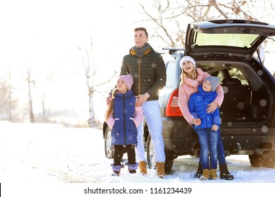 Happy Family Near Car Outdoors During Snowfall. Winter Vacation