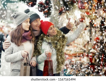 Happy Family Near The Customer Counter With Christmas Decoration At  Christmas Market