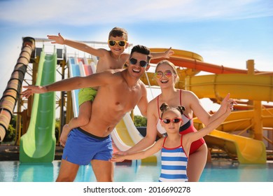 Happy family near pool in water park