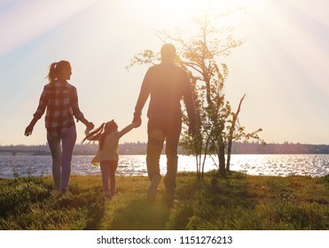 Happy Family Near River On Spring Day