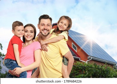 Happy Family Near Their House With Solar Panels. Alternative Energy Source