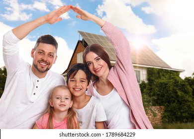 Happy Family Near Their House With Solar Panels. Alternative Energy Source